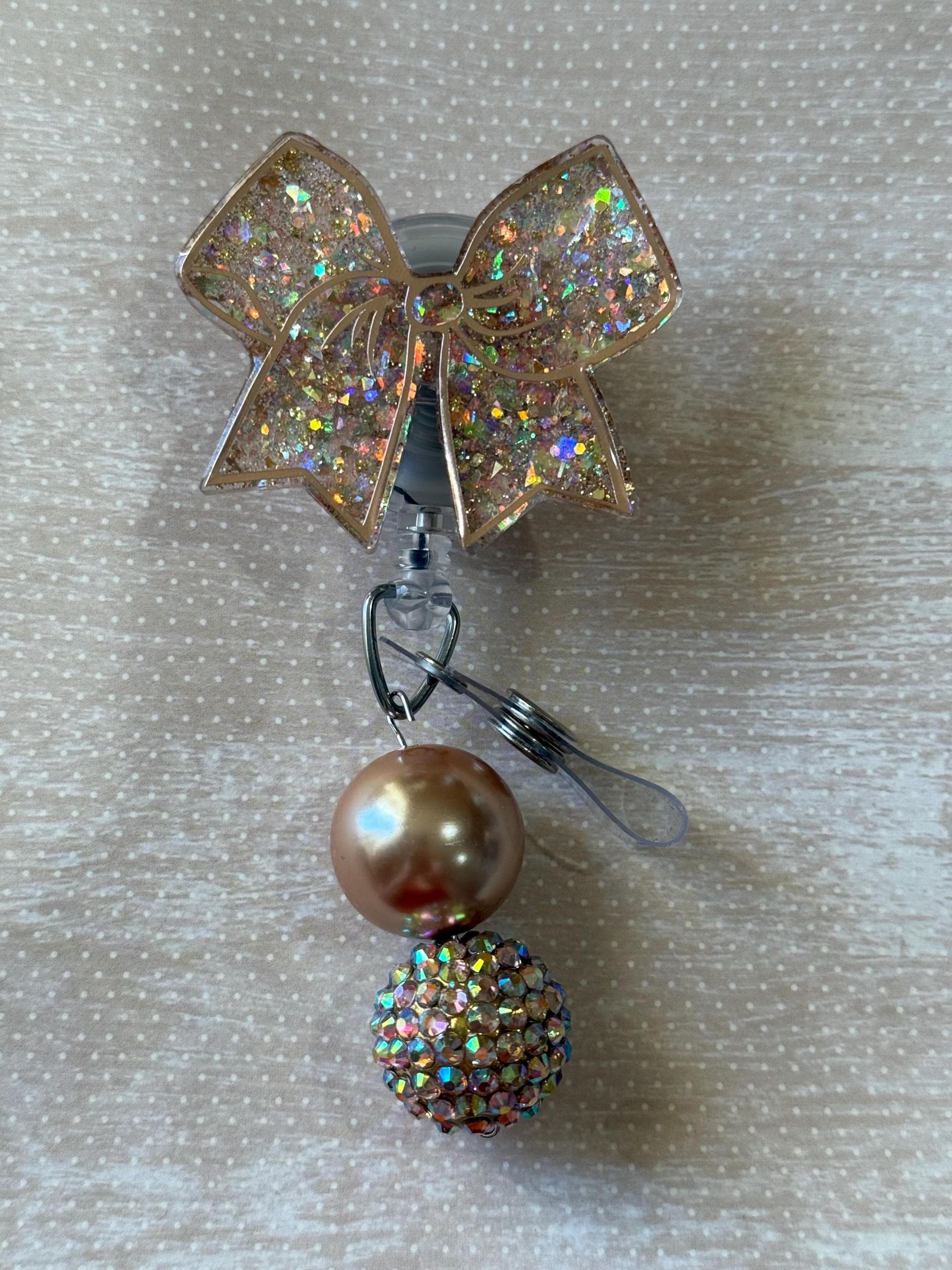 Bow badge reel swivel clip gold with beads